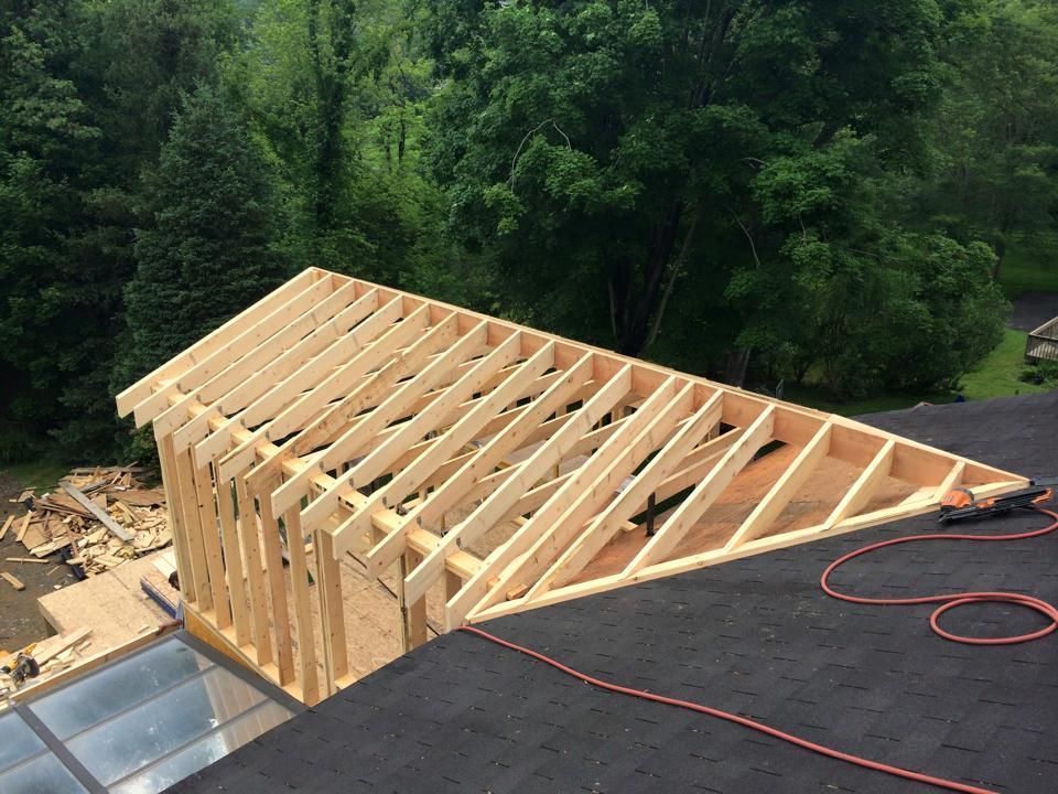 A wooden structure is being built on top of a roof.