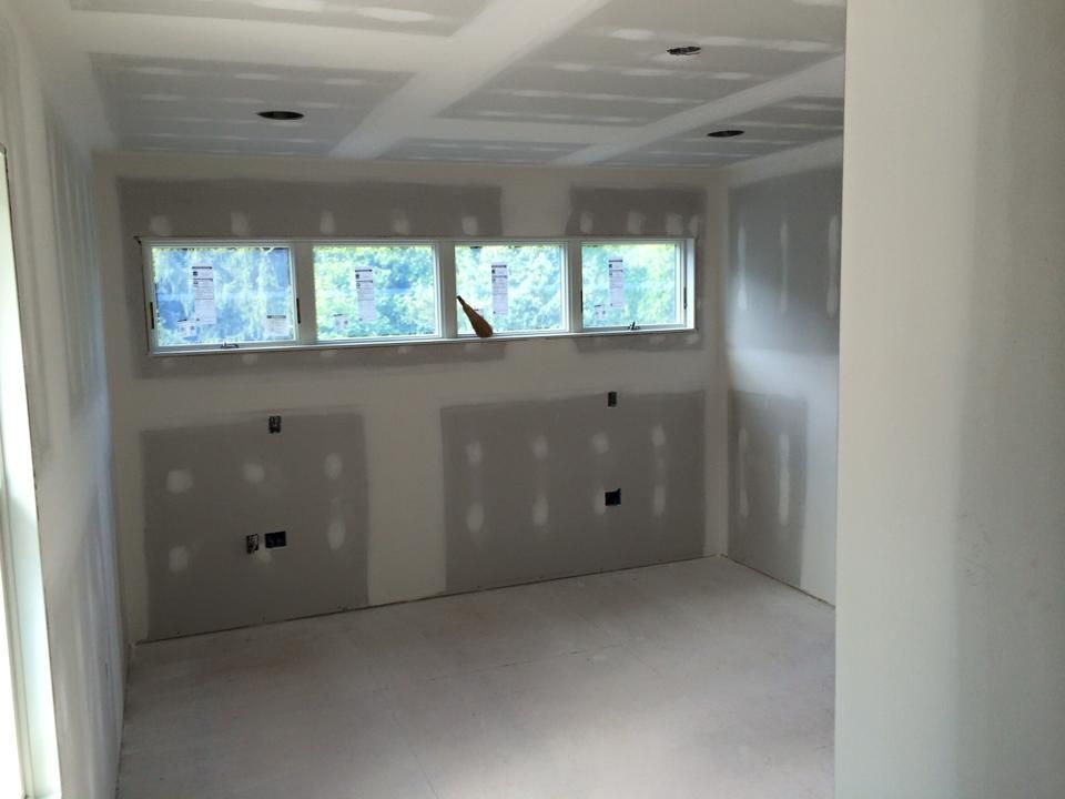 A room with a lot of windows and drywall on the walls