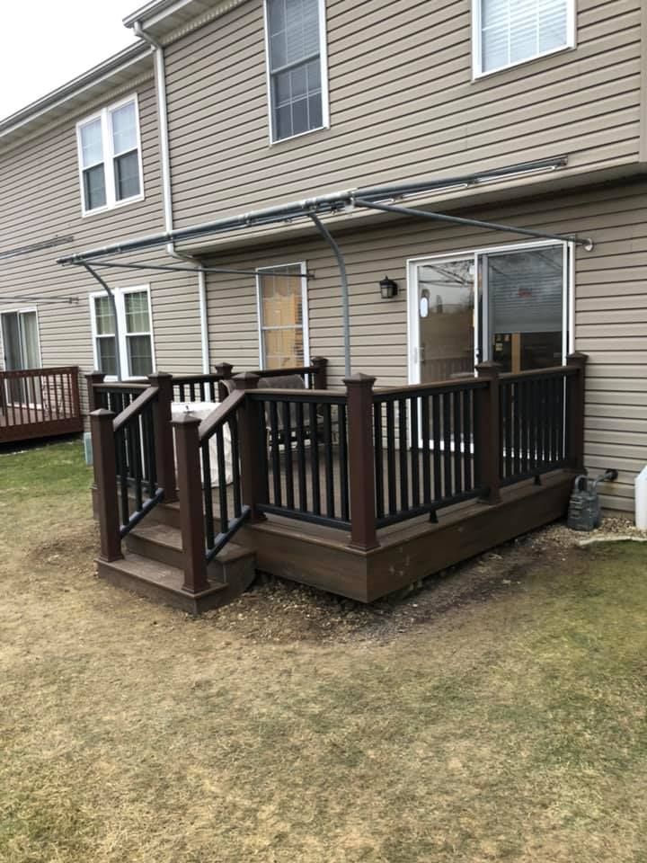 A deck with a canopy and stairs in front of a house.