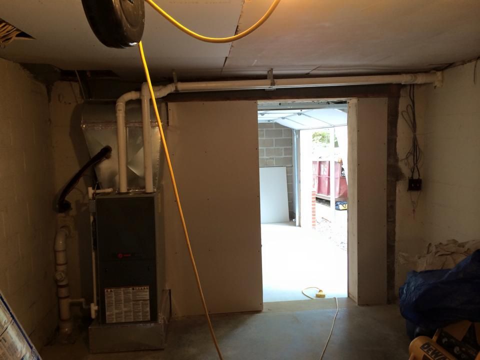 A basement with a furnace and a sliding door
