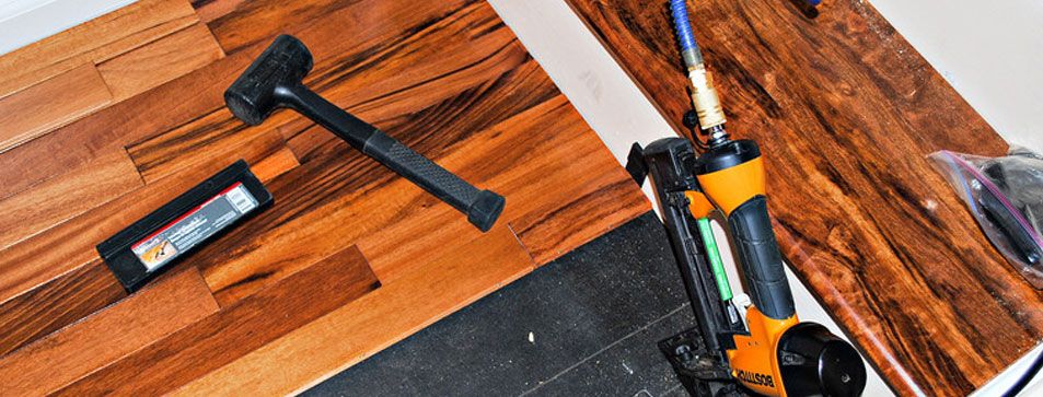 Planks, handsaw and hammer on wood flooring