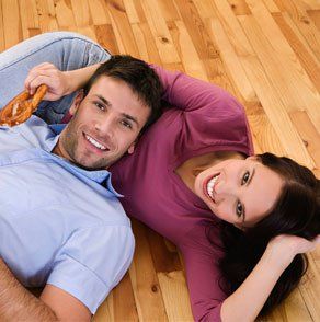 Couples sleeping on hardwood flooring