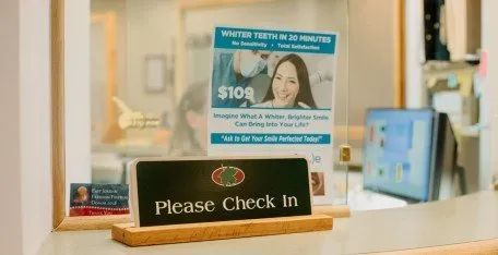 A dental office with a sign that says please check in.