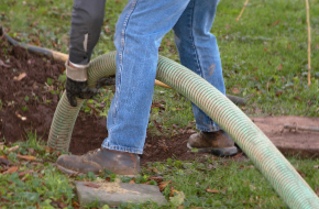 man holding line to septic tank