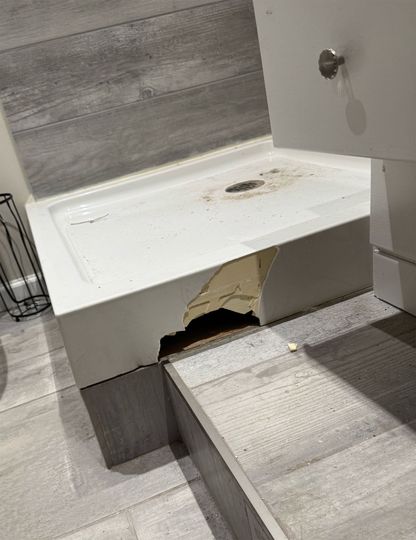 A bathtub with a hole in it in a bathroom.