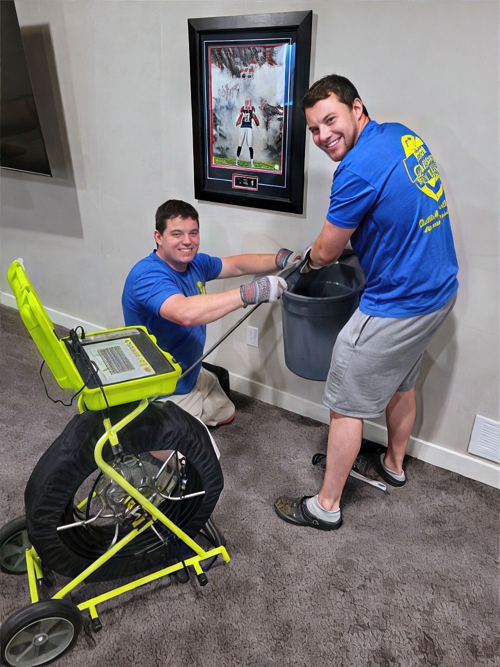 Two men are working on a drain in a basement.