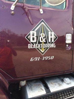 A purple truck with b & h blacktopping written on the side