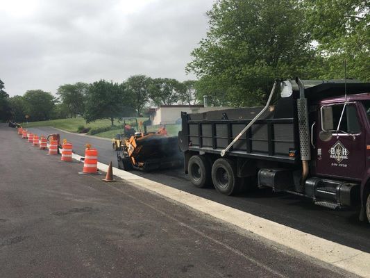 A dump truck is parked on the side of a road.
