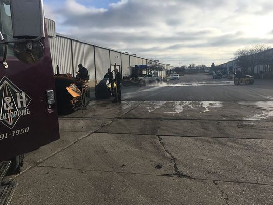 A truck is parked in a parking lot next to a building.