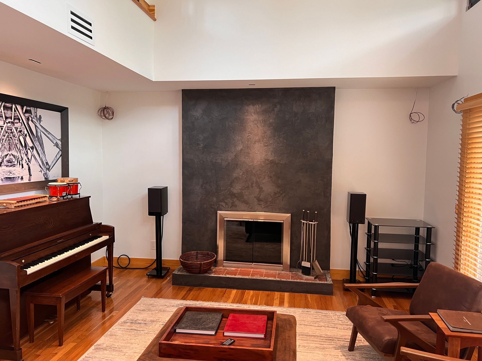 A living room with a fireplace and a piano