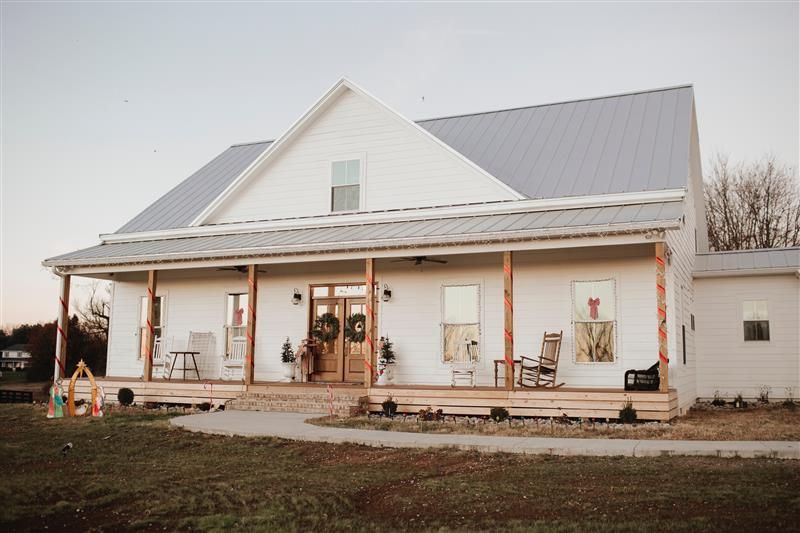 A white house with a porch and chairs on it