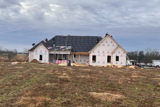 A large house is being built in a field.