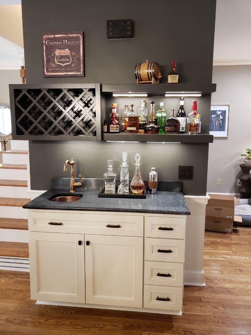 A bar with a wine rack and a sink in a living room.