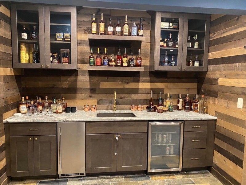 There are many bottles of alcohol on the shelves in this bar.