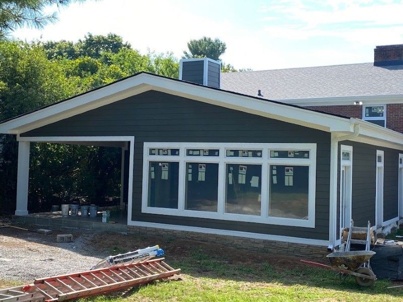 A house with a lot of windows and a ladder in front of it