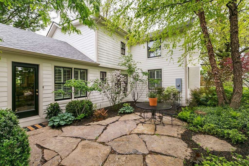 A large white house with a stone patio in front of it