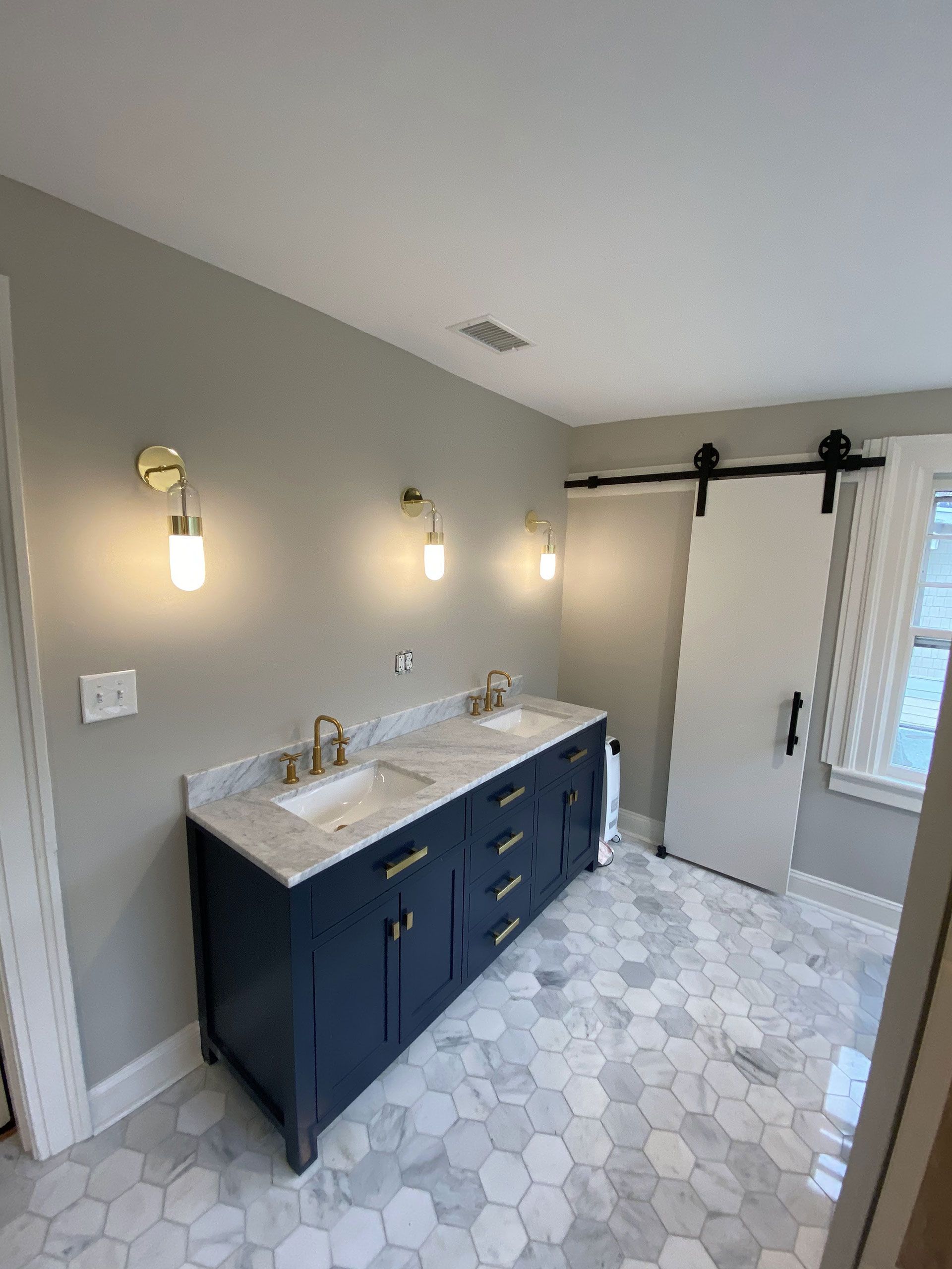 A bathroom with two sinks and a sliding barn door