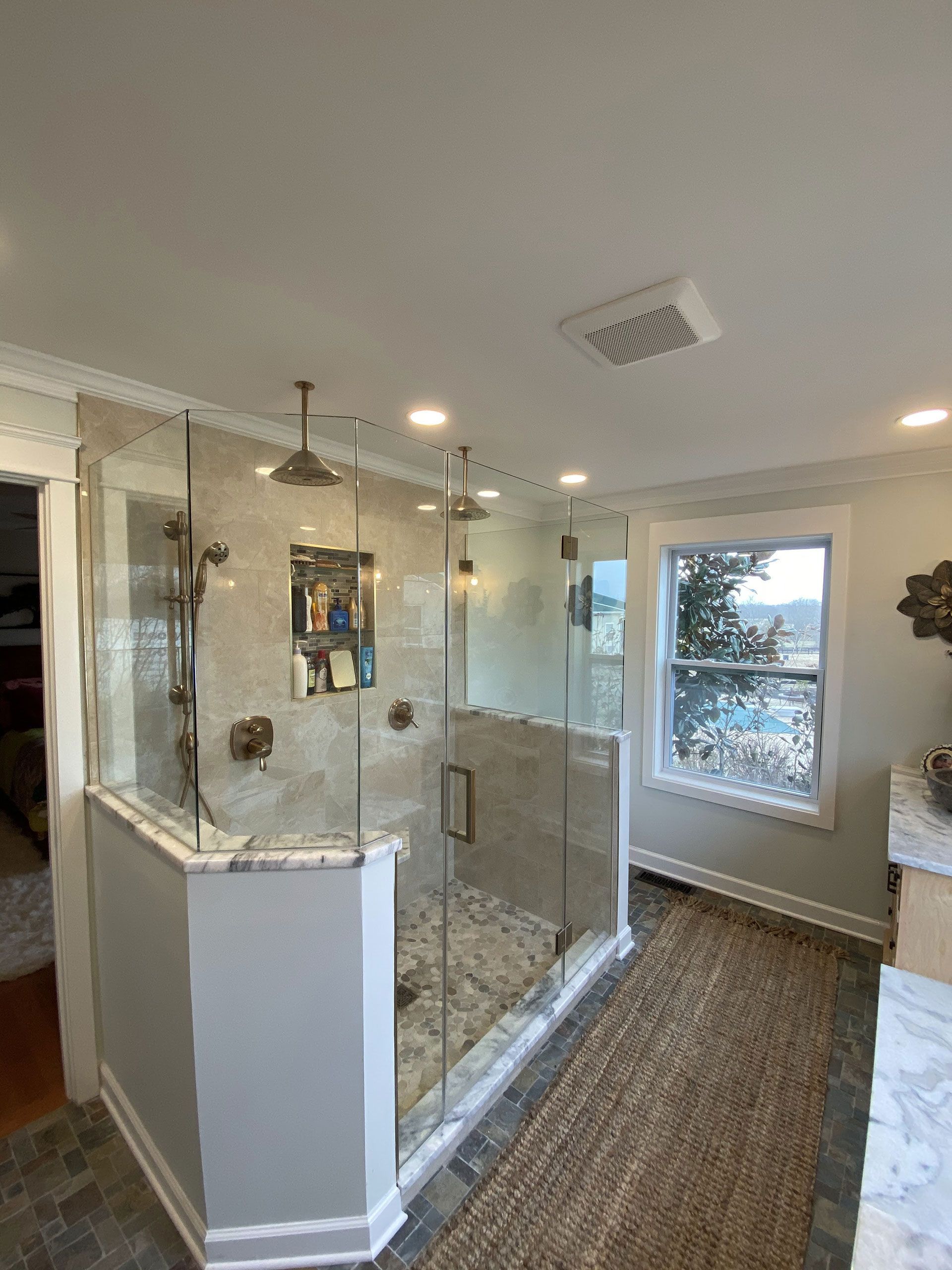 A bathroom with a walk in shower and a window