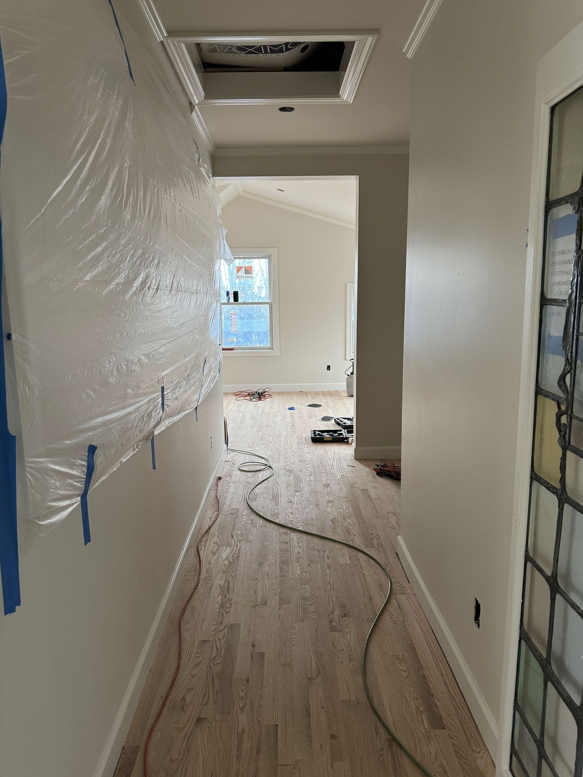 A long hallway with a ceiling fan and a stained glass window