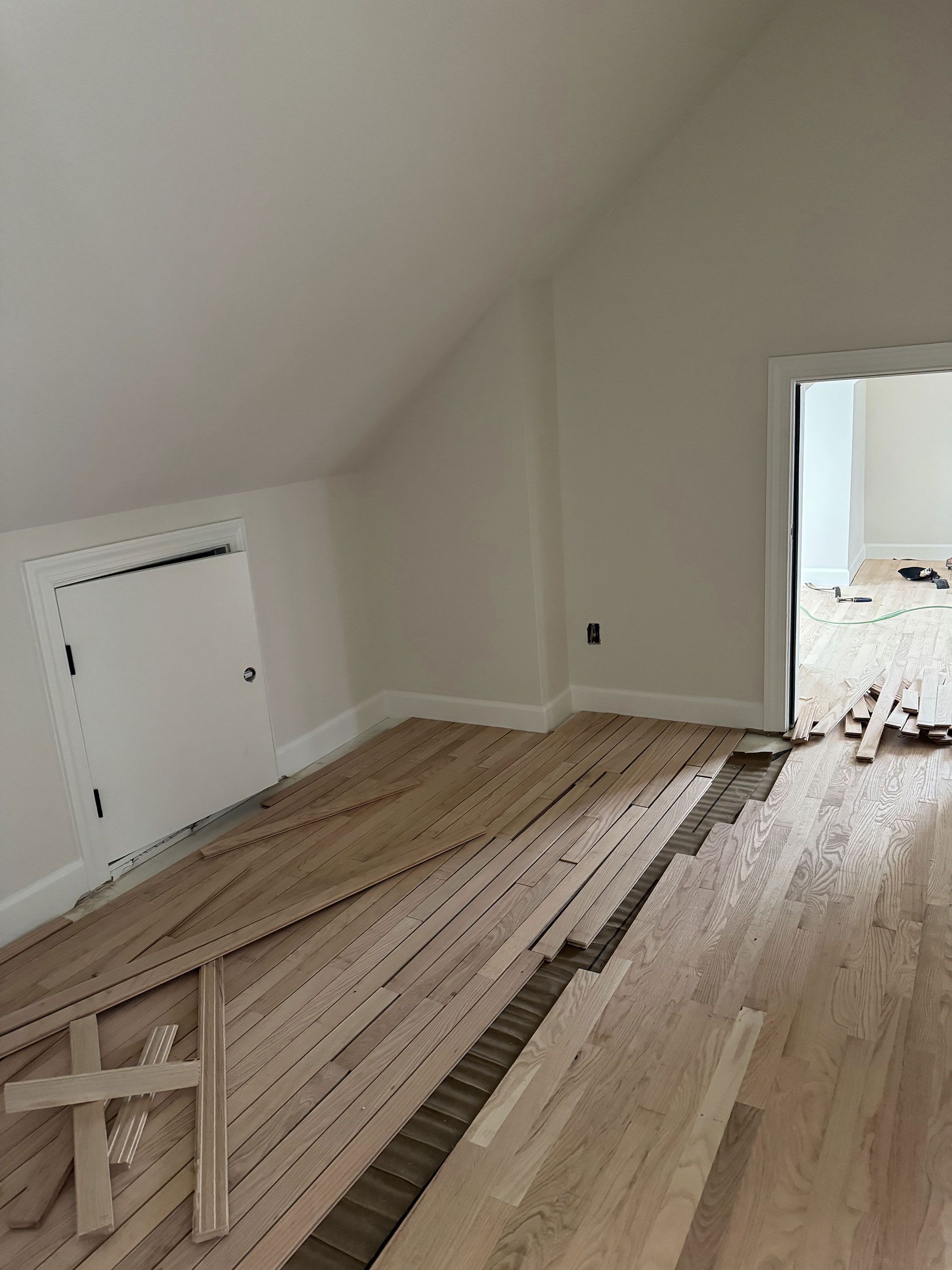 A room with hardwood floors being installed in a house.