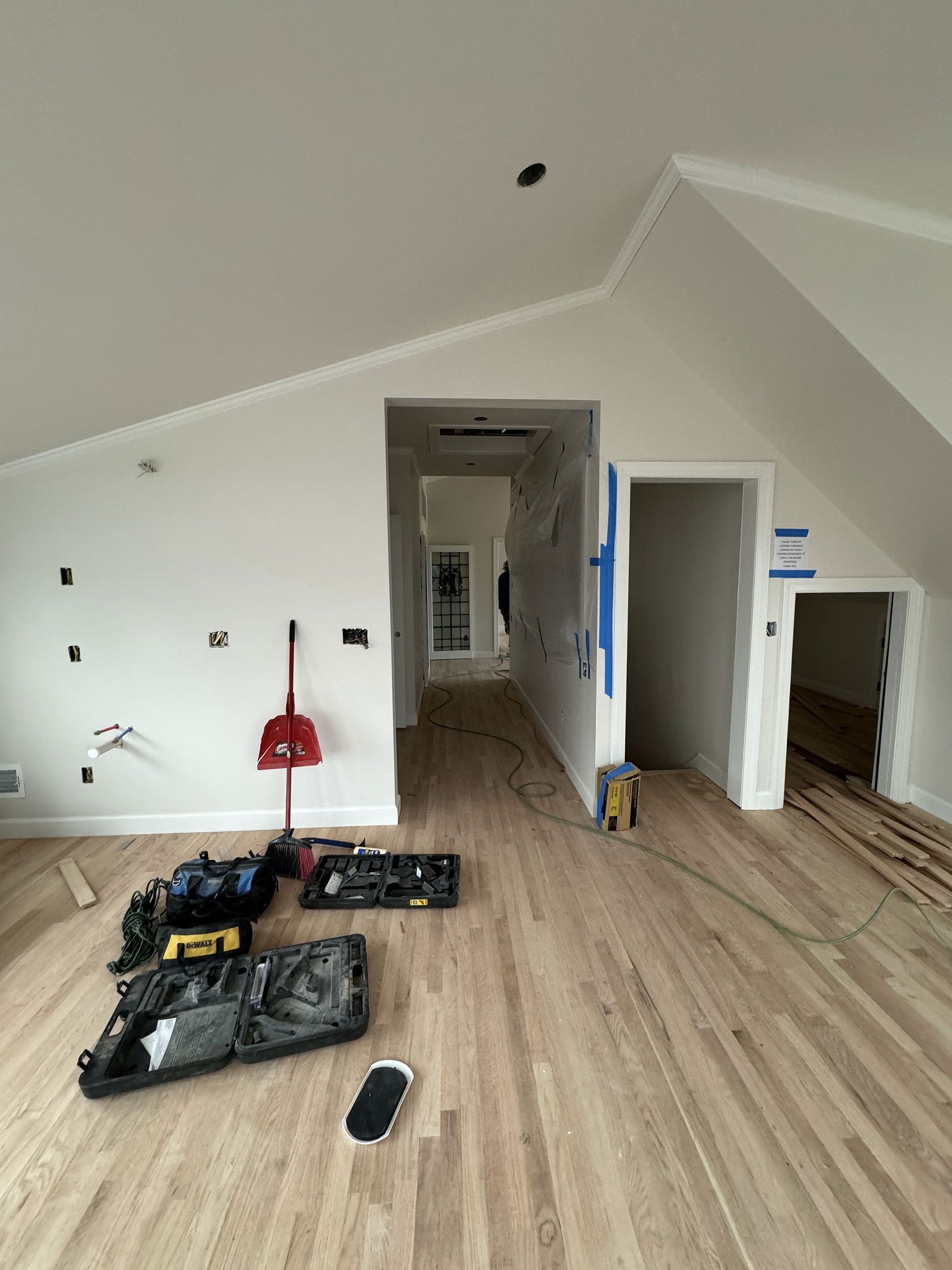 A room with hardwood floors and white walls is being remodeled