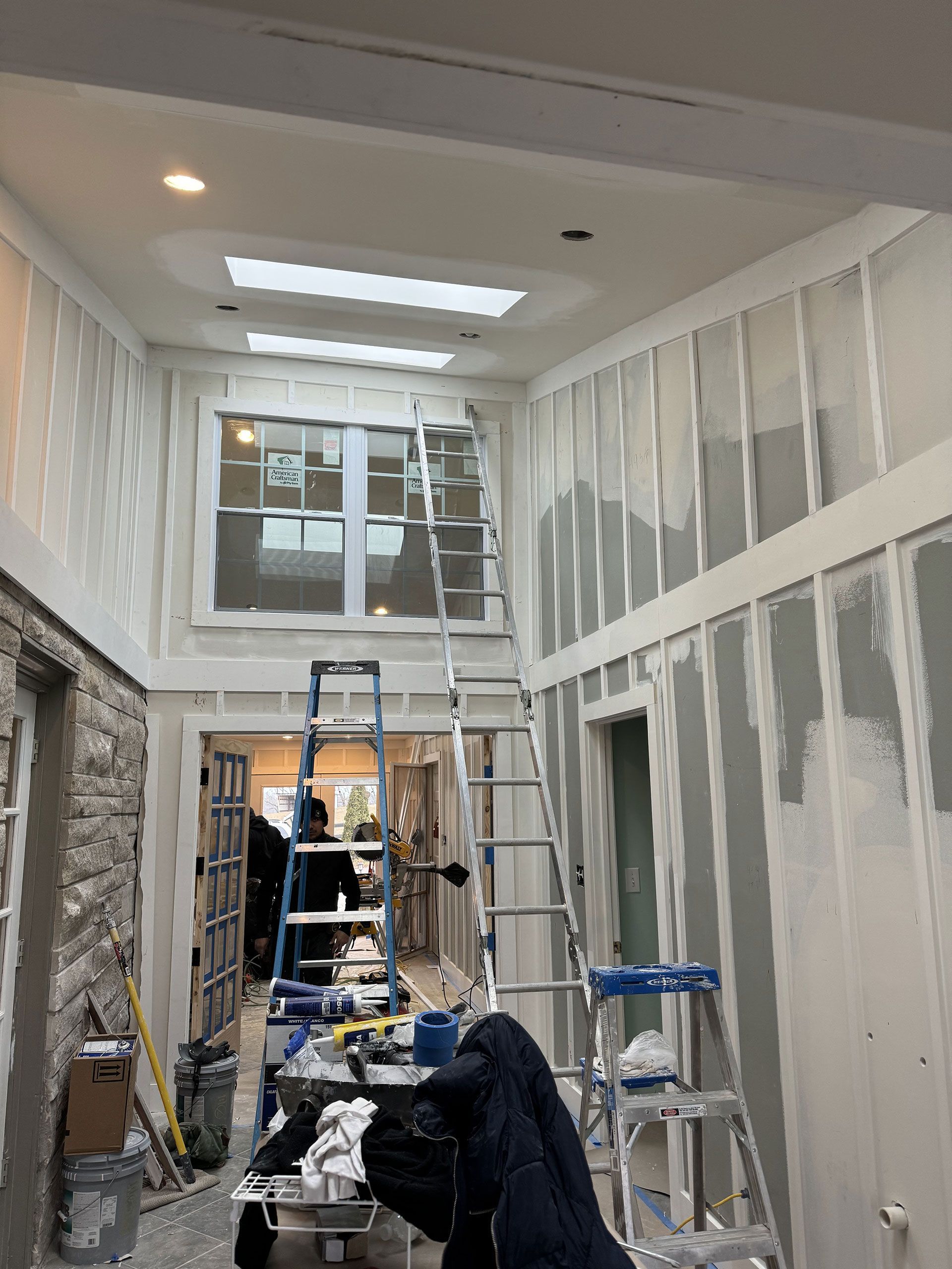 A person is standing in a room with a ladder