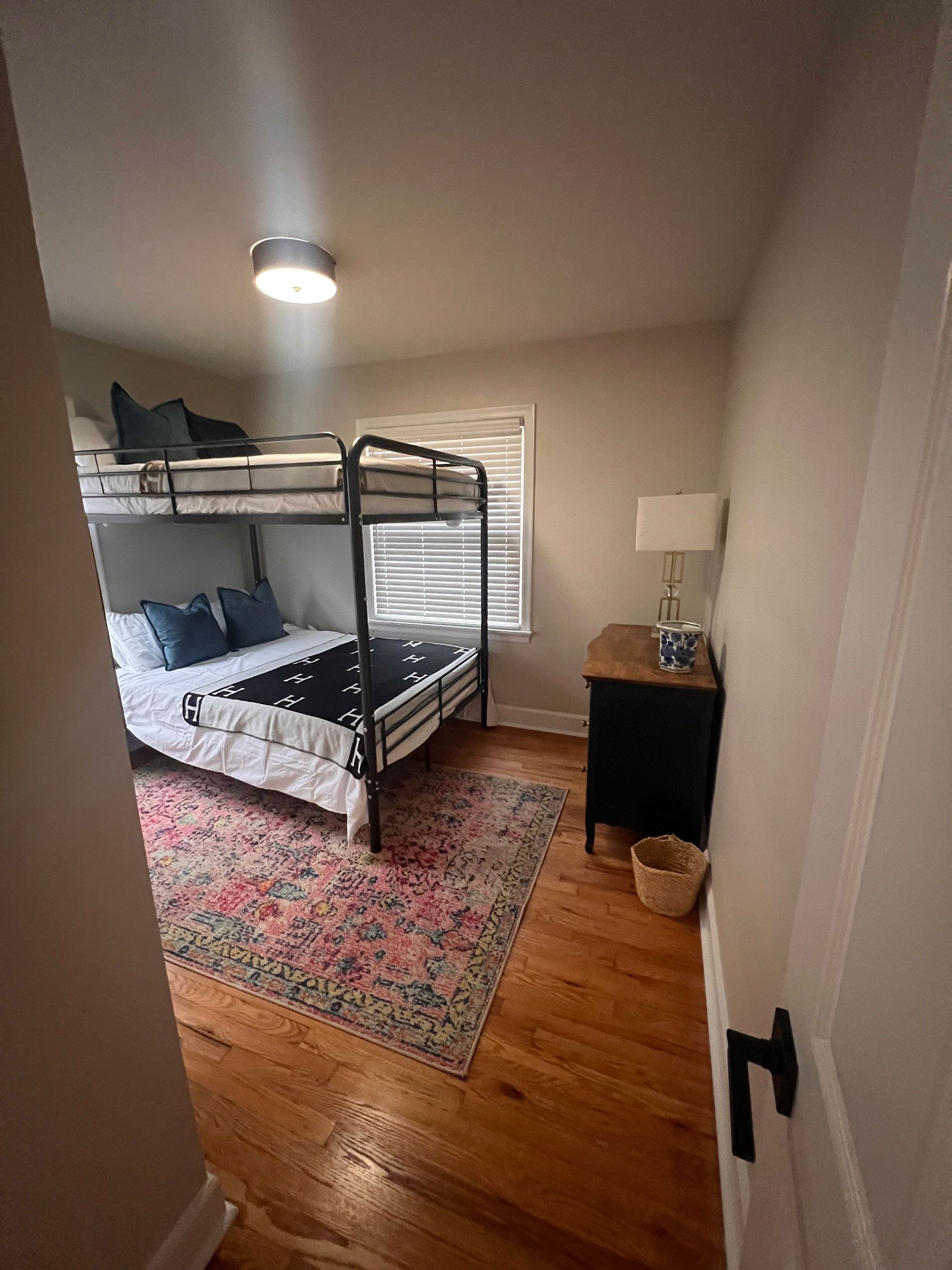 A bedroom with two bunk beds and a rug