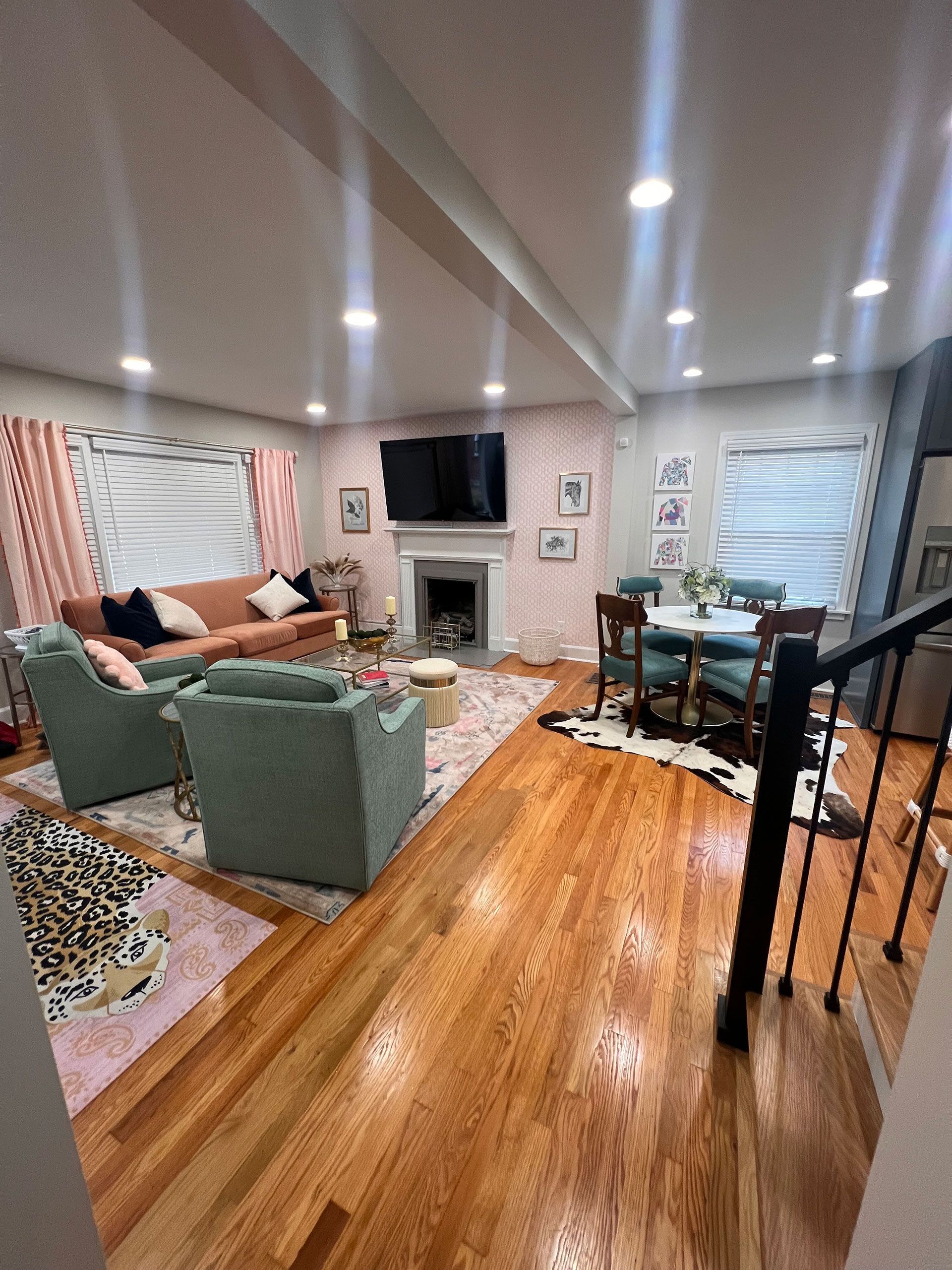 A living room with a couch, chairs, a fireplace and a television