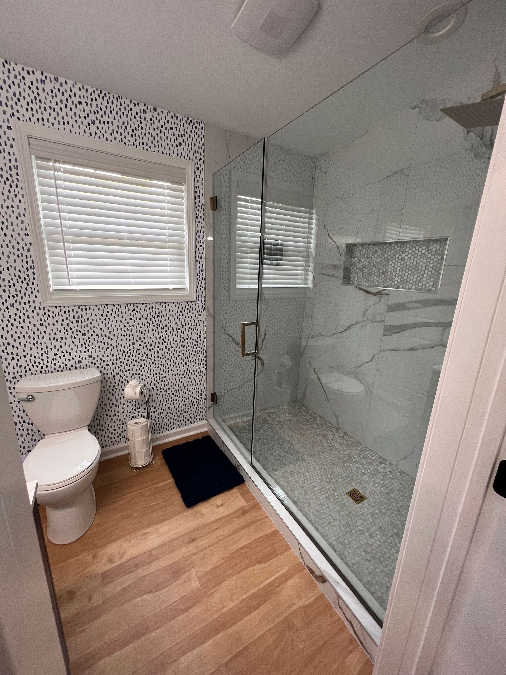 A bathroom with a toilet, shower and window