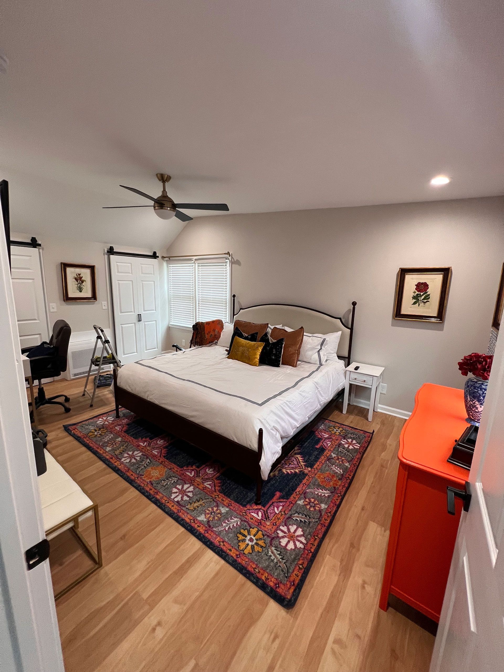 A bedroom with a large bed and a rug on the floor