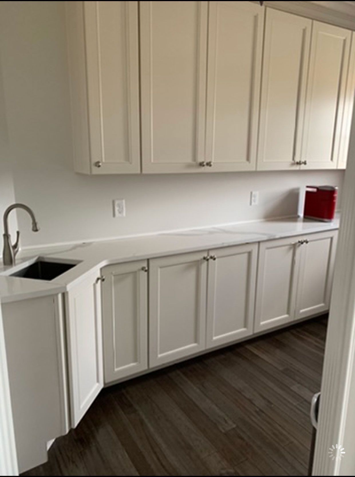 A kitchen with white cabinets and a sink