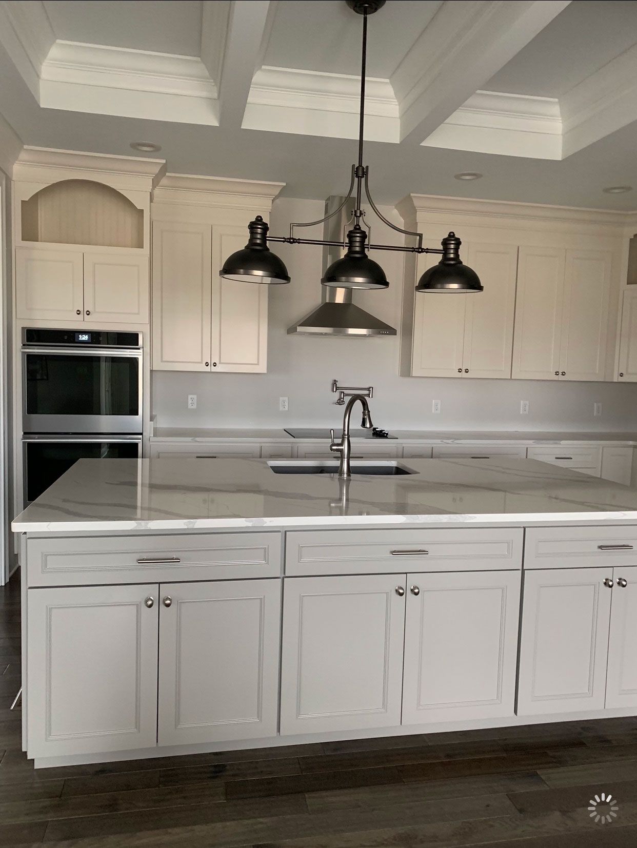 A kitchen with white cabinets and a large island