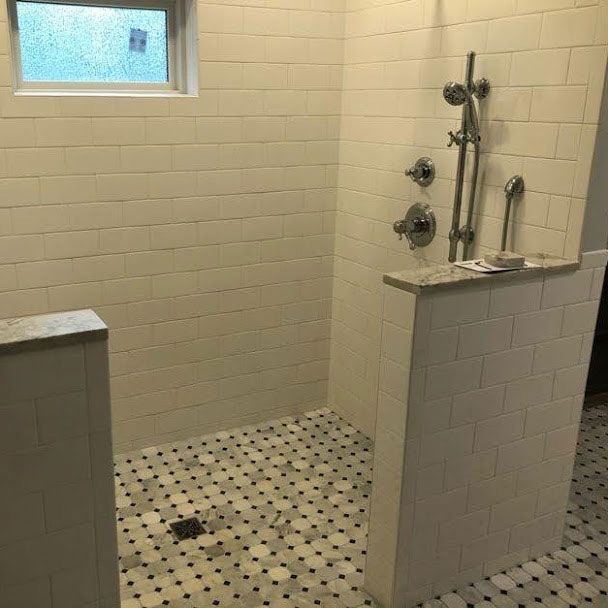 A bathroom with a walk in shower and a window