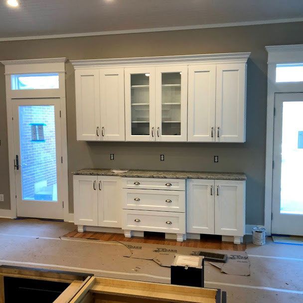 A kitchen with white cabinets and granite counter tops