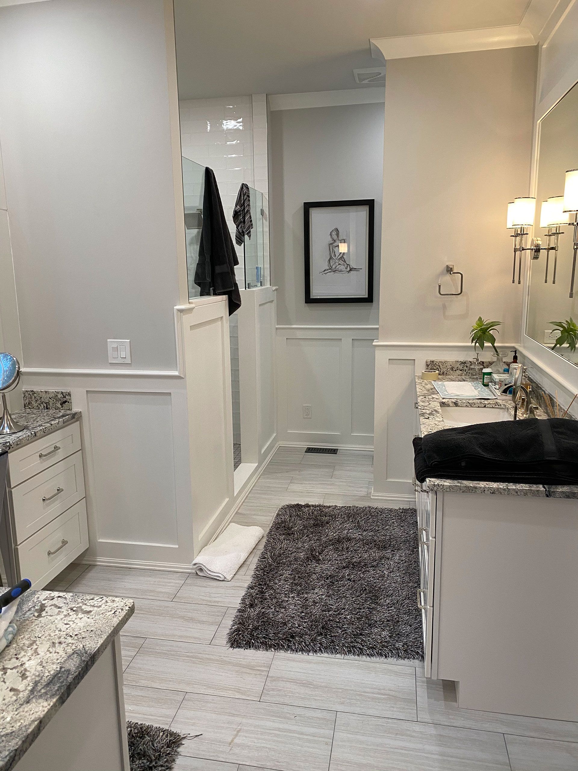 A bathroom with two sinks, a rug, and a mirror
