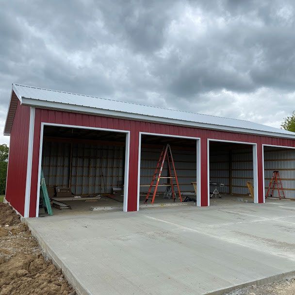 A red garage with a white roof is being built on a cloudy day