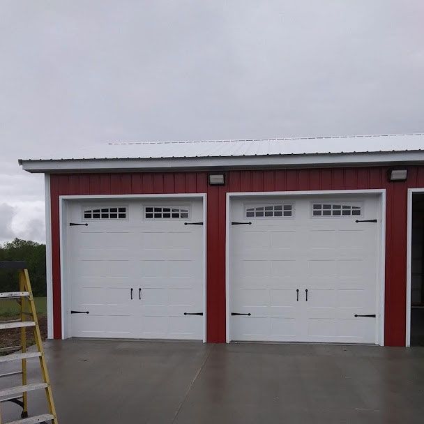 A red garage with a white roof is being built on a cloudy day