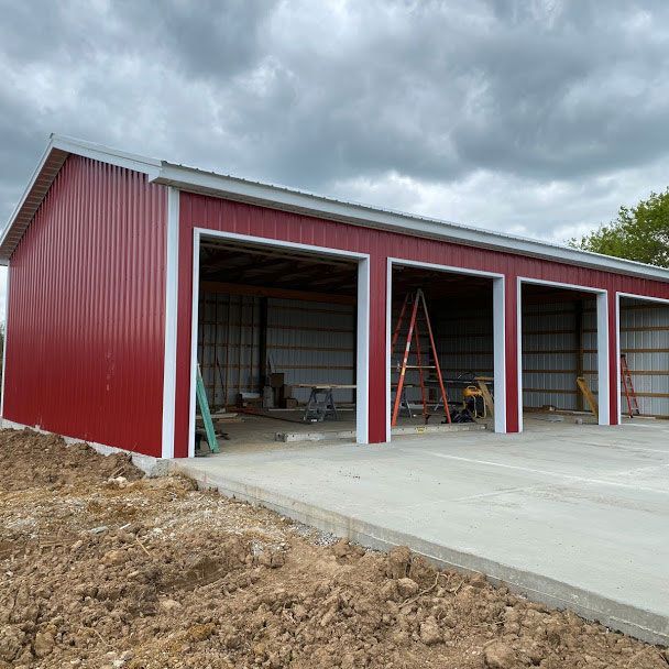 A red garage with four garage doors is under construction