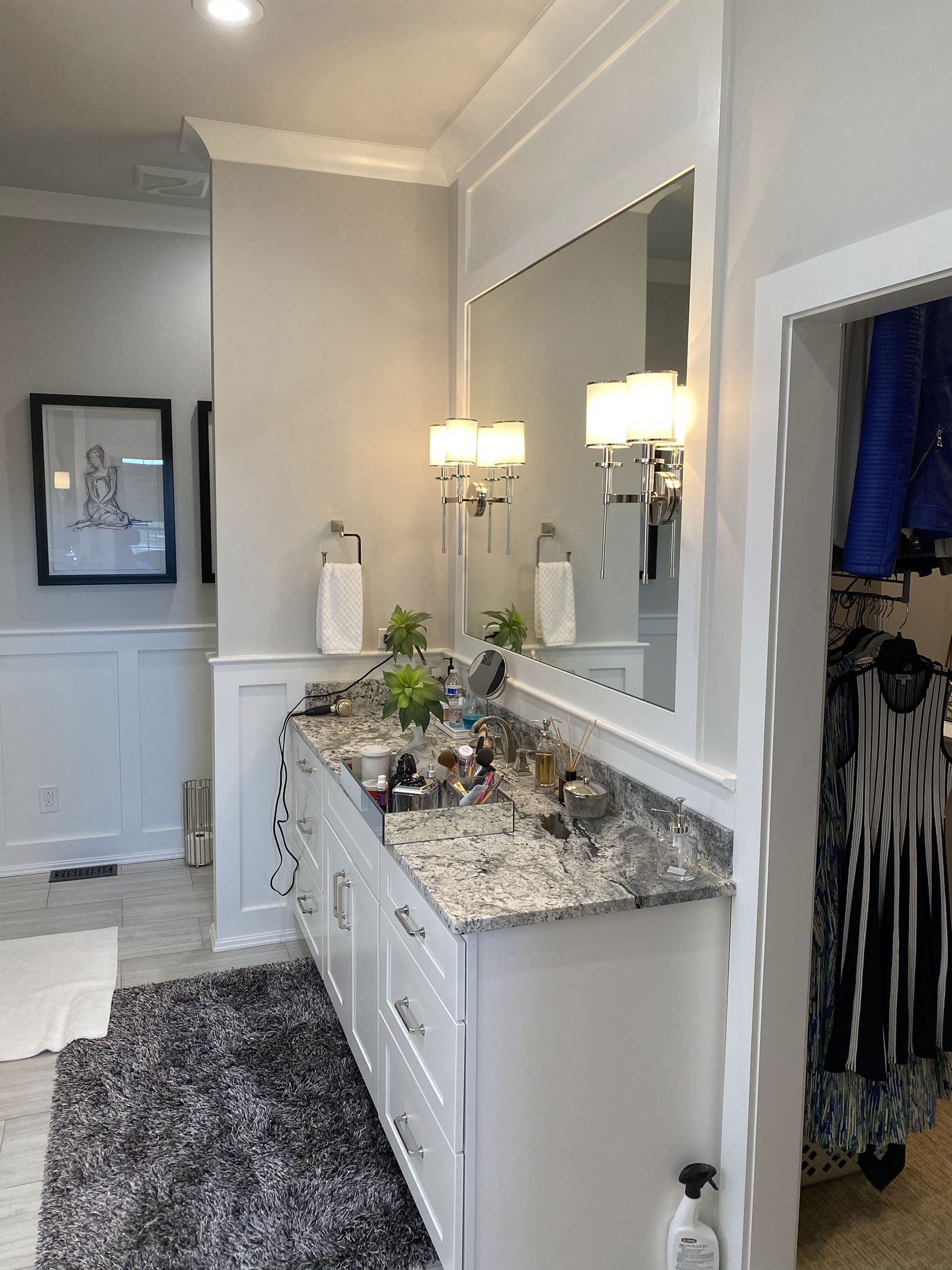 A bathroom with two sinks, a large mirror and a rug