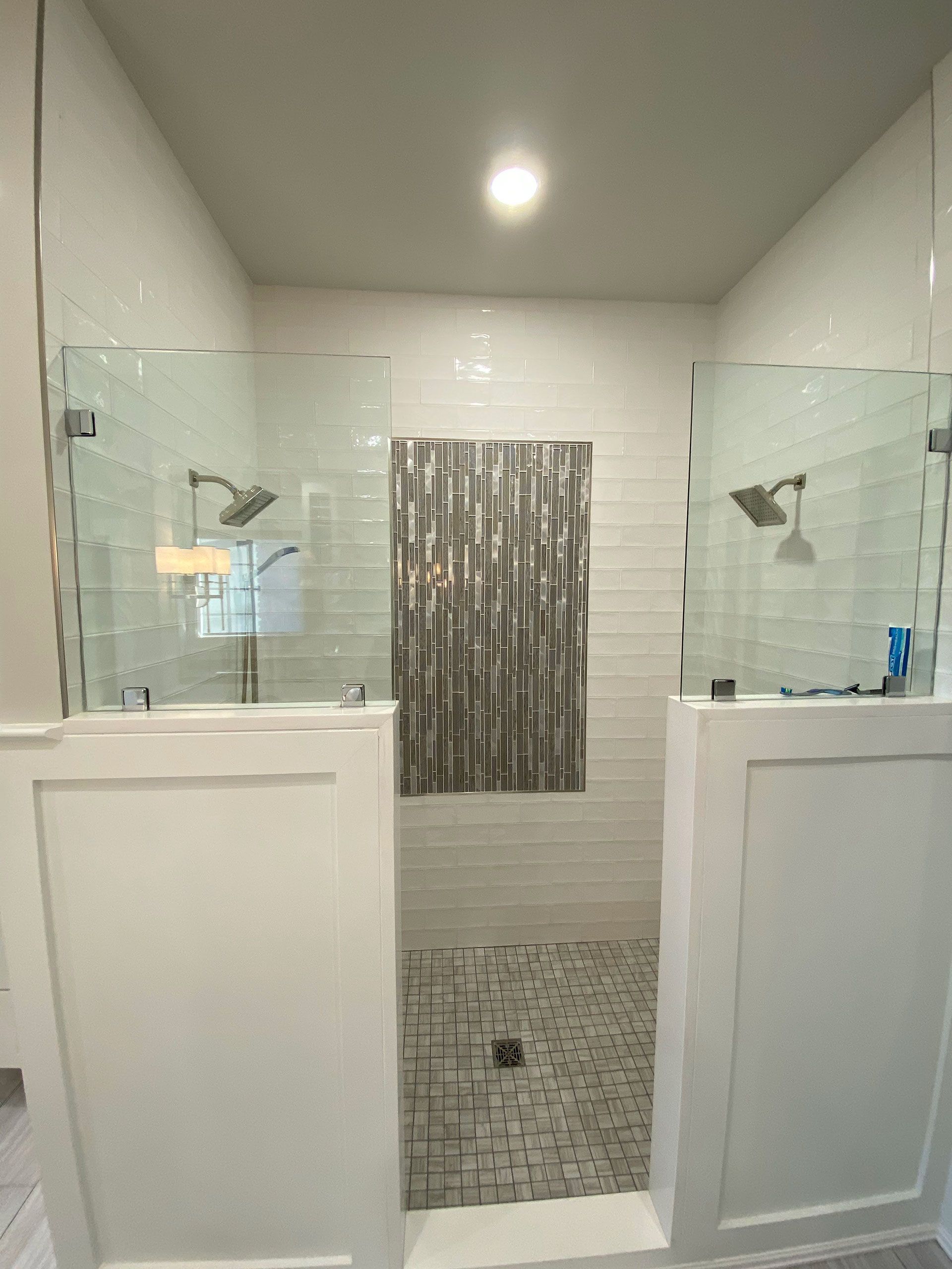 A bathroom with two walk in showers and a tiled floor