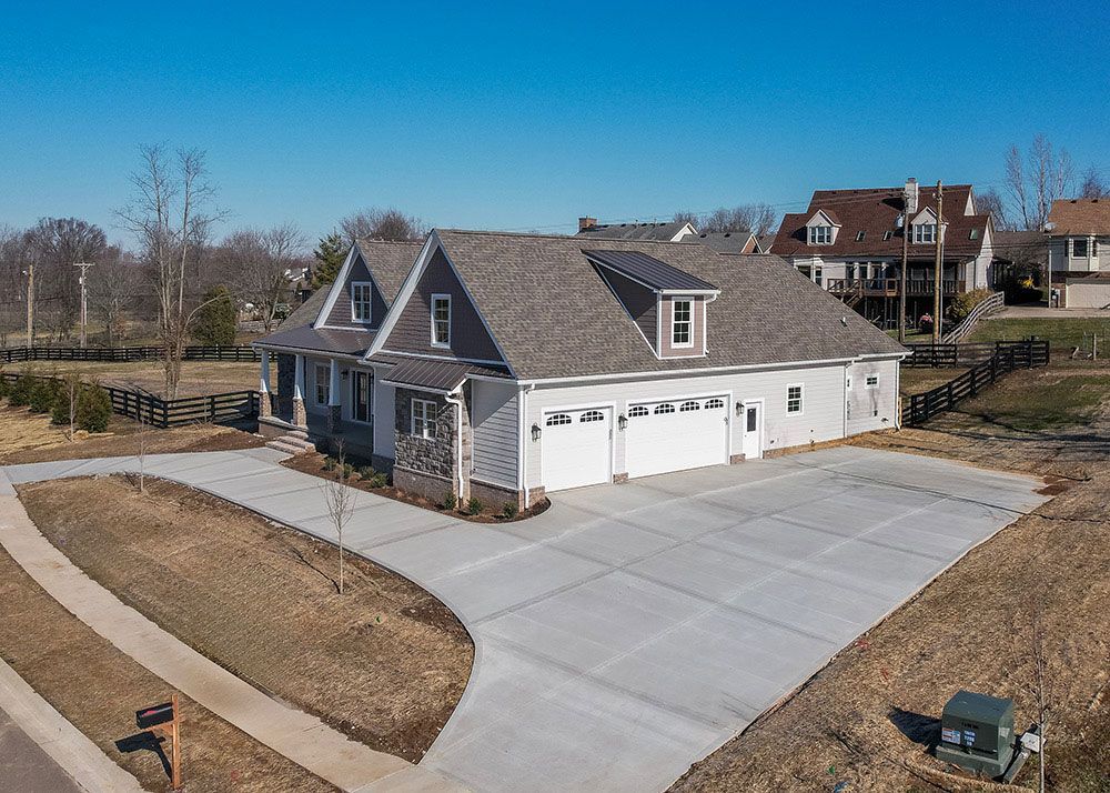 An aerial view of a house with two garages and a driveway.