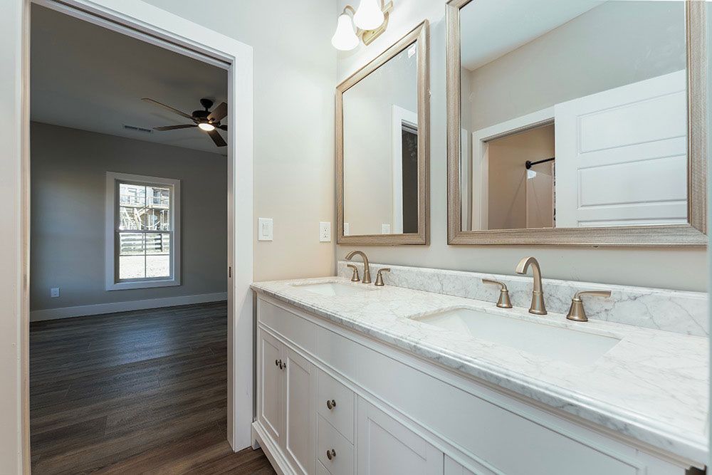 A bathroom with two sinks and two mirrors