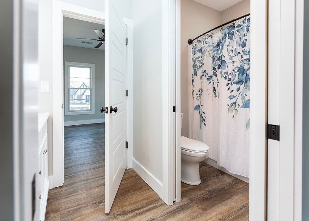 A bathroom with a toilet and a shower curtain