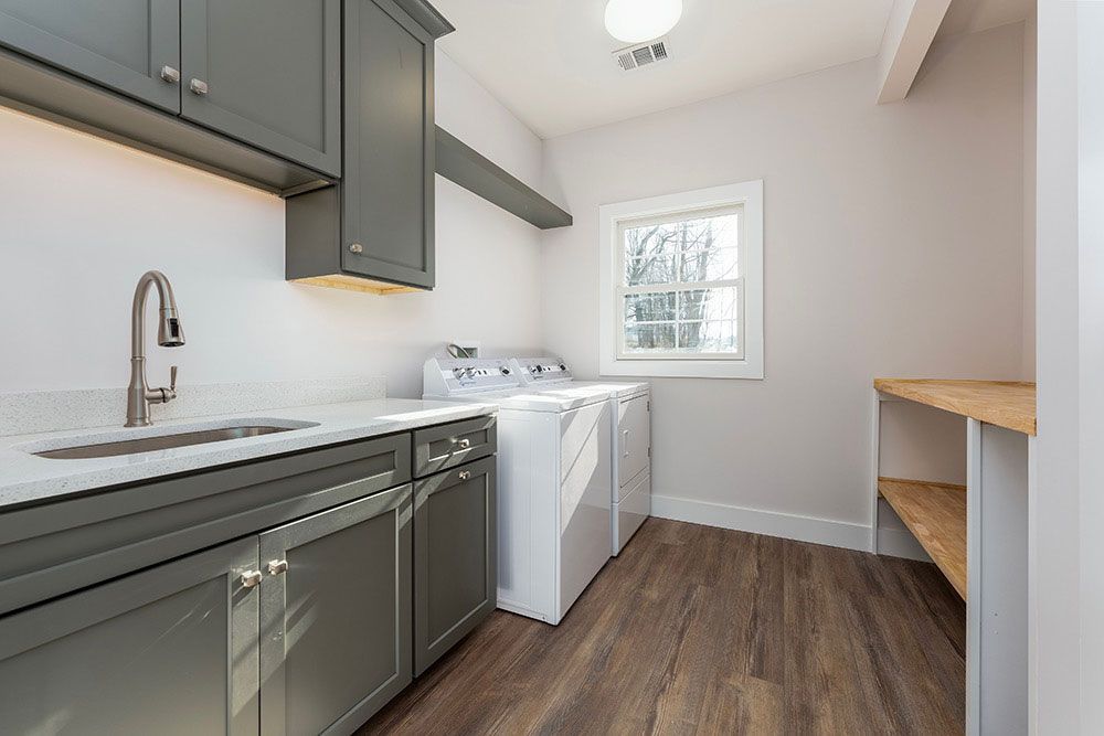 A laundry room with a washer and dryer and a sink.