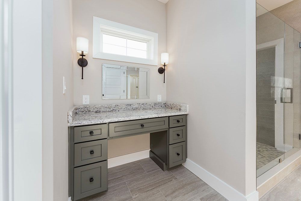 A bathroom with a vanity, sink, mirror and walk in shower