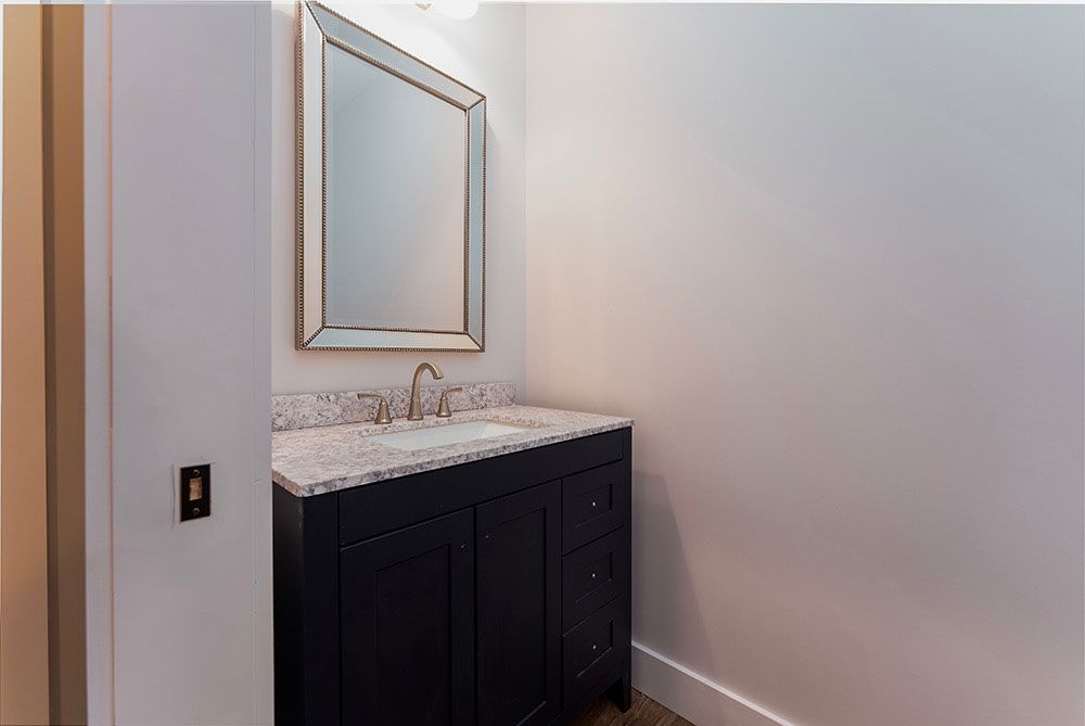 A bathroom with a sink, mirror and vanity