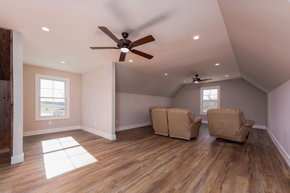 A living room with a ceiling fan and two chairs.