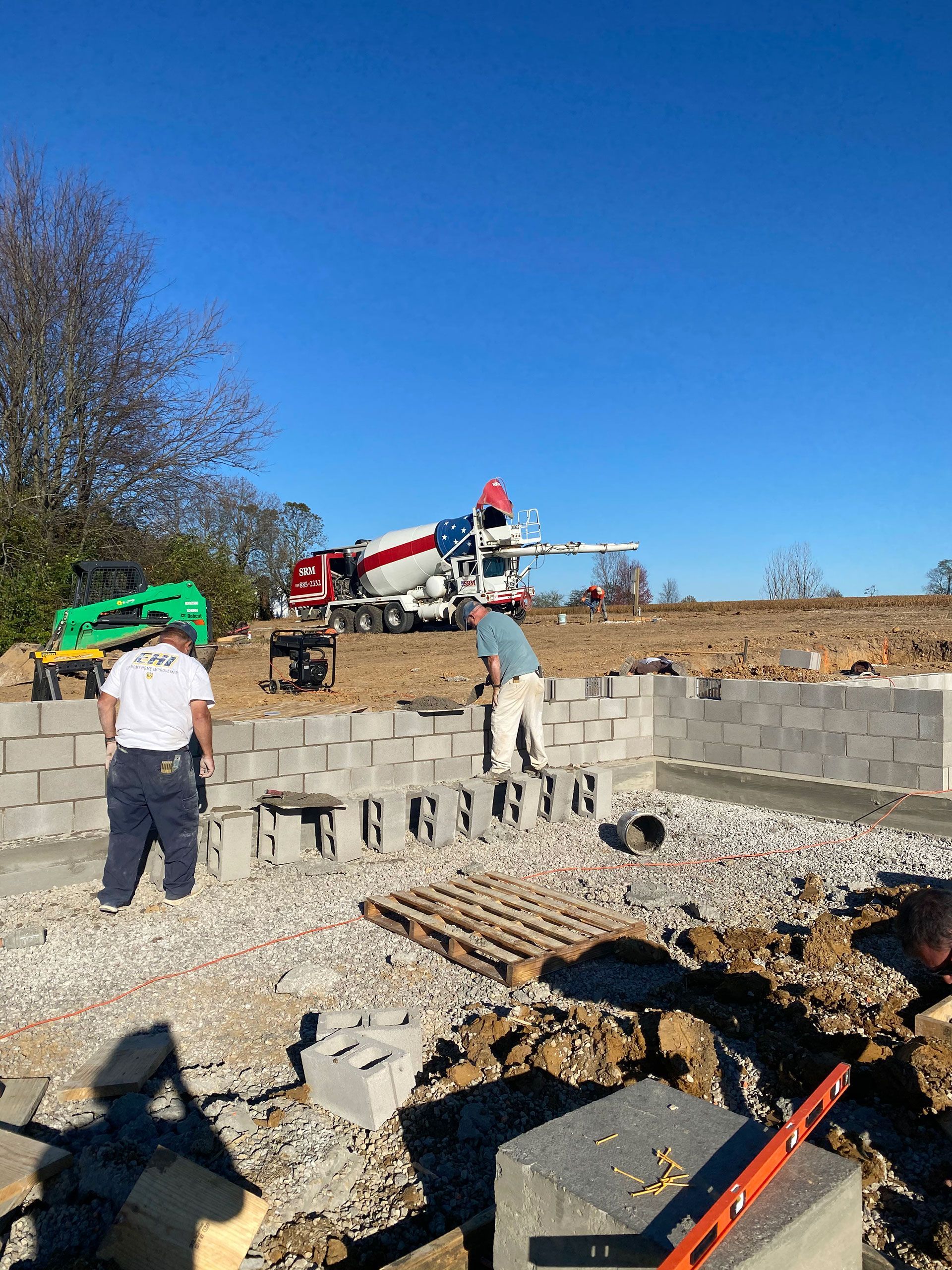 A concrete truck is pouring concrete on a construction site.