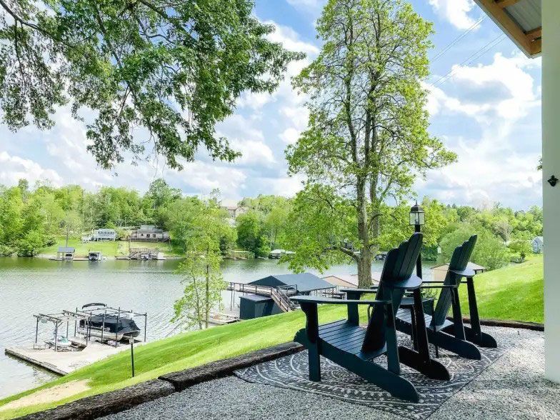A row of chairs are sitting on a patio overlooking a lake
