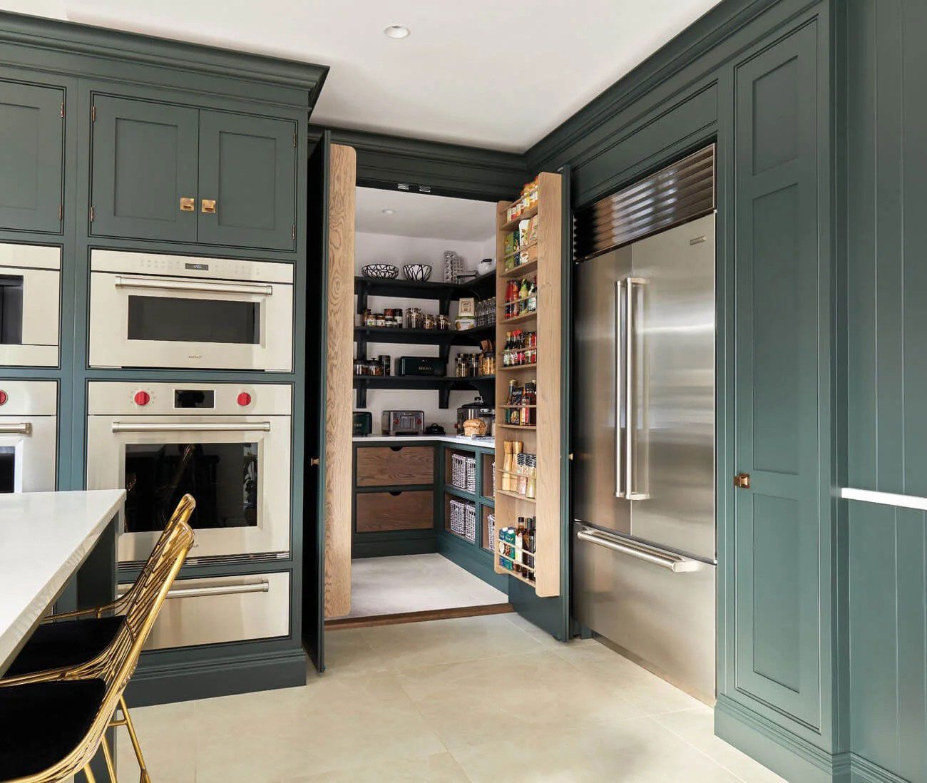 A kitchen with stainless steel appliances and green cabinets